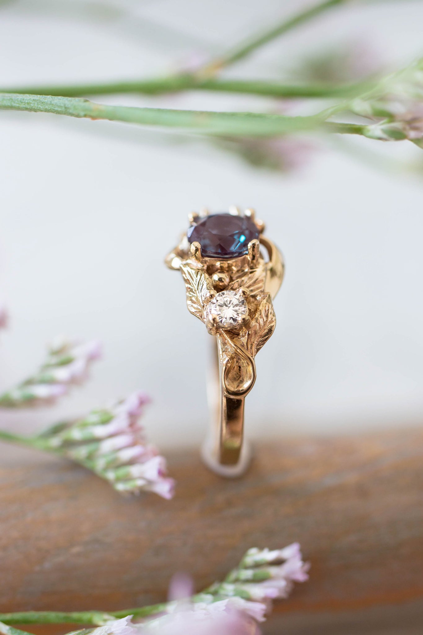this ring holds alexandrite birth stone for june. golden ring with round cut gemstone, side view