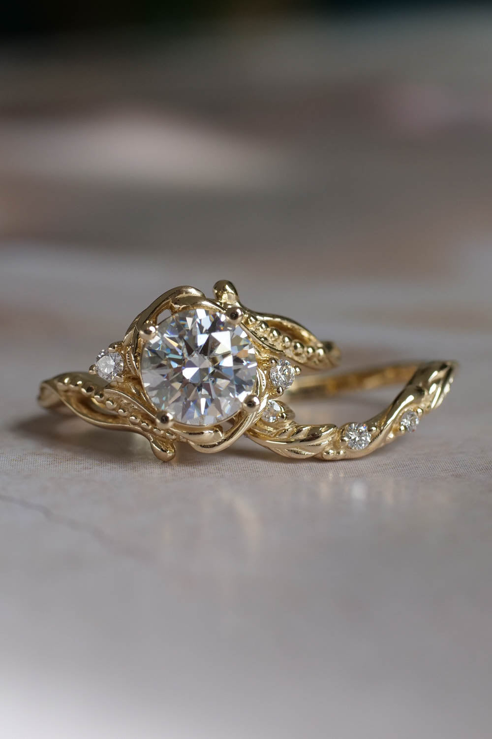 1 carat moissanite engagement ring  in yellow gold with small saide diamonds arround the ring