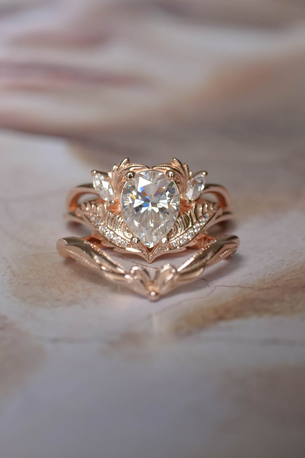 This unique engagement ring features author's design inspired by nature. Solid gold ring is adorned with pear cut moissanite, accent stones: marquise cut and round cut diamonds.